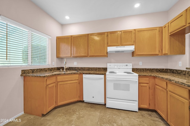 kitchen with sink, white appliances, and dark stone countertops