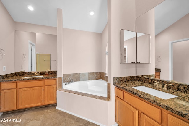 bathroom with a tub to relax in, vanity, and vaulted ceiling