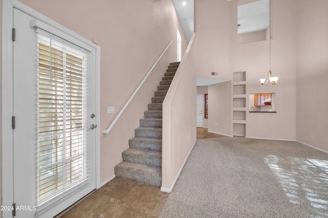 interior space with a high ceiling, an inviting chandelier, and carpet flooring