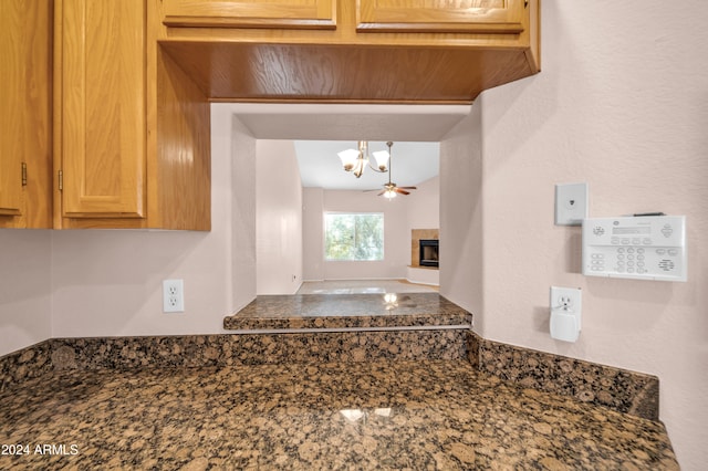 kitchen with dark stone countertops, hanging light fixtures, and ceiling fan