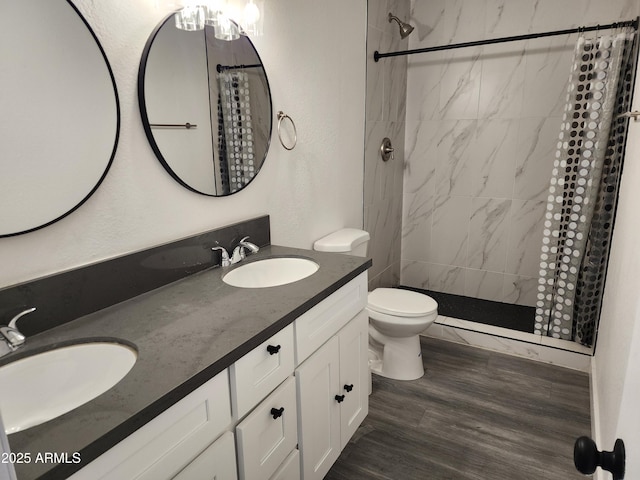 bathroom with a sink, toilet, and tiled shower