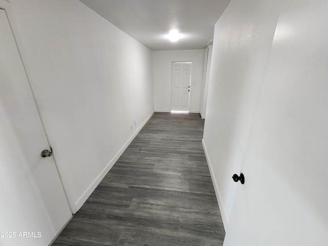 corridor featuring dark wood-style floors and baseboards