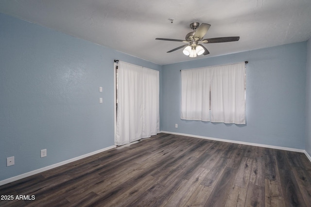 empty room with ceiling fan and dark wood-type flooring