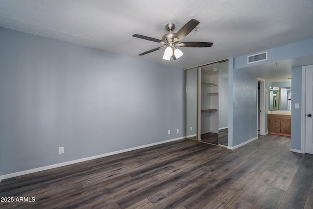 unfurnished bedroom with connected bathroom, ceiling fan, and dark hardwood / wood-style floors