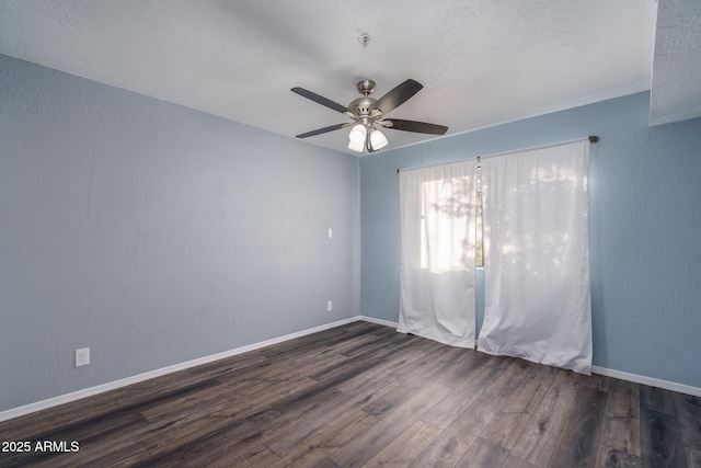 empty room with ceiling fan and dark hardwood / wood-style flooring