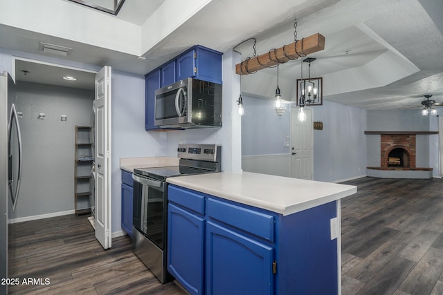 kitchen featuring dark hardwood / wood-style flooring, blue cabinets, a fireplace, and appliances with stainless steel finishes