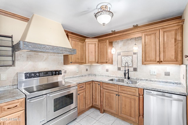 kitchen featuring sink, decorative backsplash, premium range hood, and appliances with stainless steel finishes