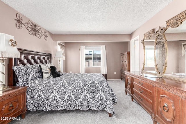 bedroom featuring multiple windows, light carpet, and a textured ceiling