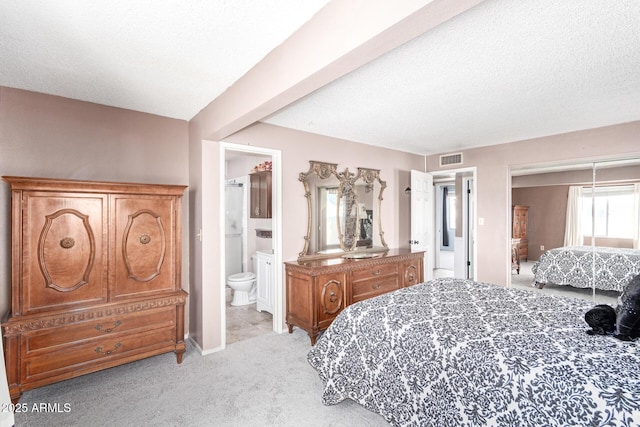 bedroom featuring ensuite bath, light carpet, a textured ceiling, a closet, and beam ceiling