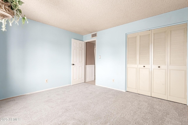 unfurnished bedroom with a closet, carpet floors, and a textured ceiling