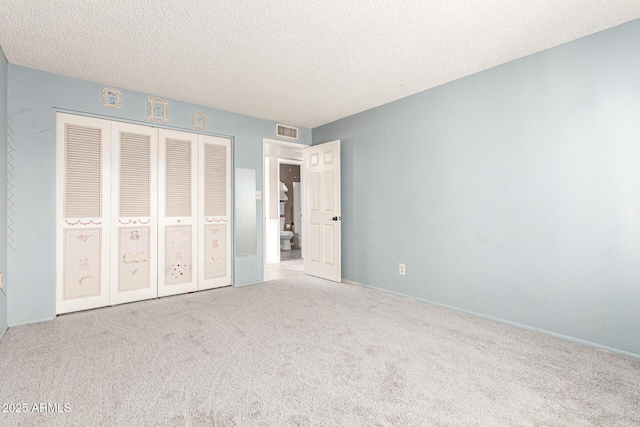 unfurnished bedroom with carpet floors, a closet, and a textured ceiling