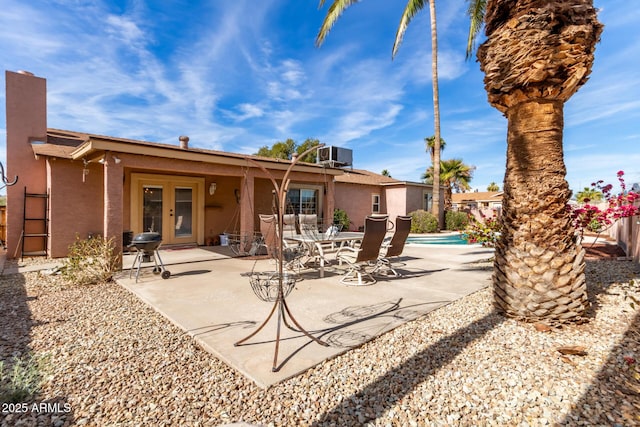 rear view of property with central AC unit, a patio area, and french doors