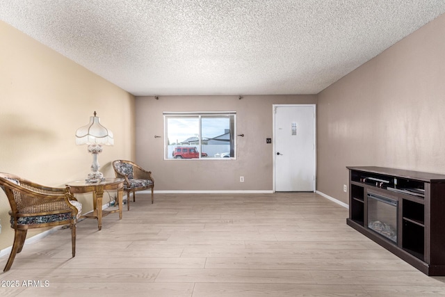 living area featuring light hardwood / wood-style floors and a textured ceiling