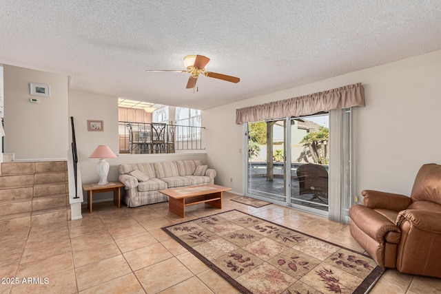 tiled living room featuring ceiling fan and a textured ceiling