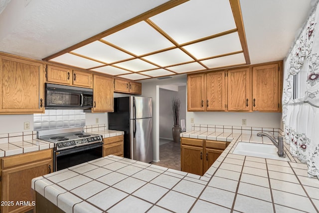 kitchen featuring sink, appliances with stainless steel finishes, tasteful backsplash, tile countertops, and kitchen peninsula