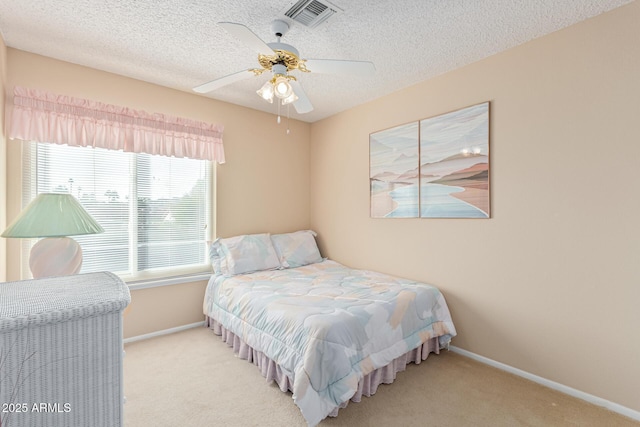 carpeted bedroom featuring a textured ceiling and ceiling fan