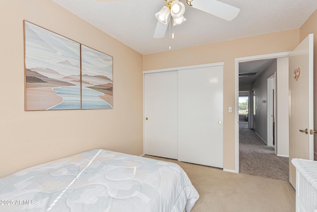 carpeted bedroom with a textured ceiling, ceiling fan, and a closet