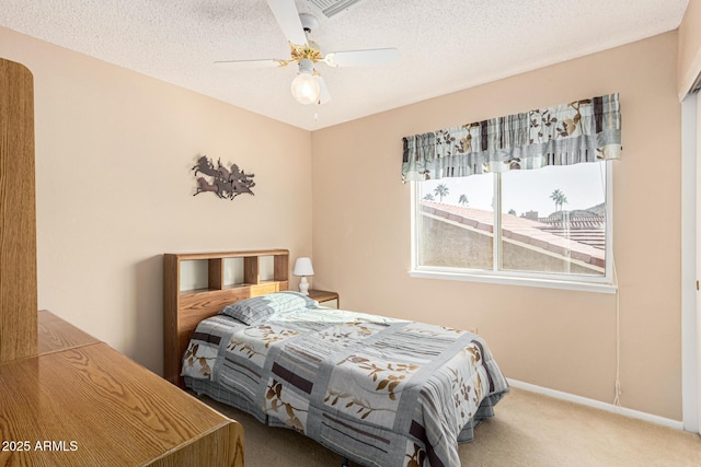 bedroom featuring ceiling fan, a textured ceiling, and carpet flooring