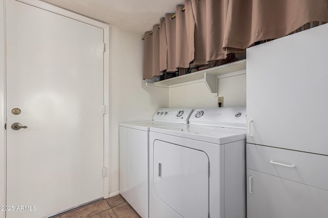 laundry room featuring washing machine and dryer and light tile patterned floors