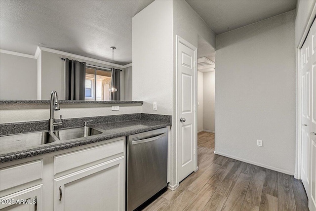 20100 N 78th Pl Unit 2019, Scottsdale, AZ 85255 - kitchen featuring stainless steel dishwasher, dark countertops, light wood-style flooring, crown molding, and white cabinets
