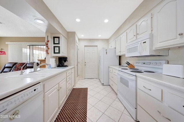 kitchen with white cabinets, light tile patterned flooring, white appliances, and sink