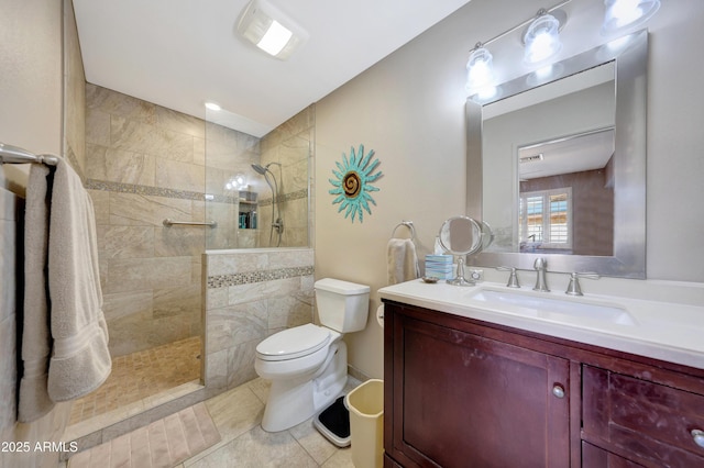 bathroom with tile patterned floors, vanity, toilet, and a tile shower