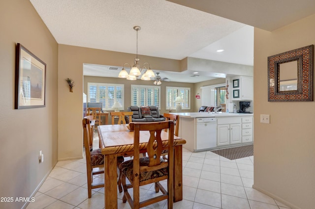 tiled dining space with a textured ceiling and ceiling fan with notable chandelier