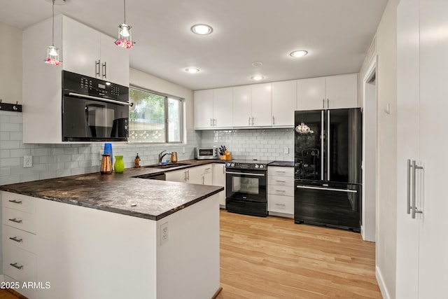 kitchen with hanging light fixtures, sink, white cabinets, and black appliances