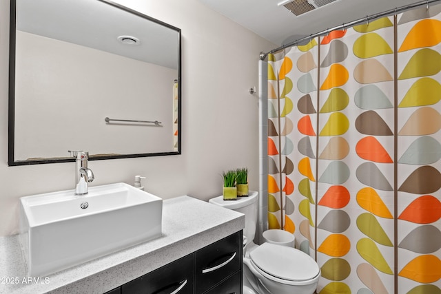 bathroom with vanity, curtained shower, and toilet