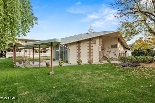 rear view of property featuring a lanai, a lawn, and a patio area