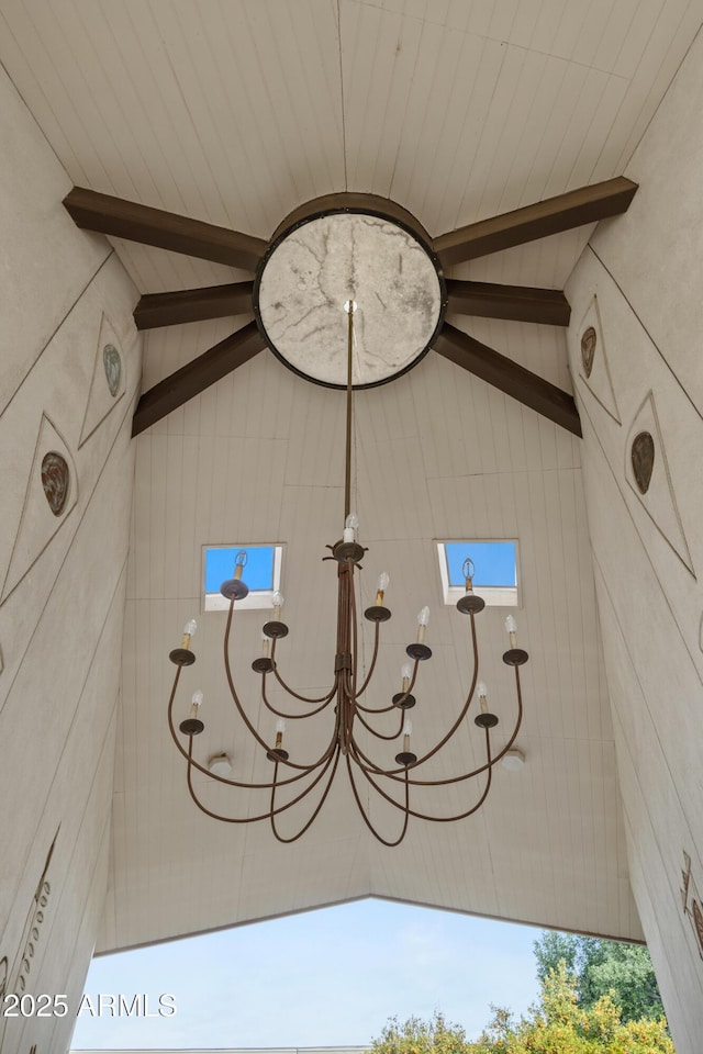 details featuring an inviting chandelier and beam ceiling