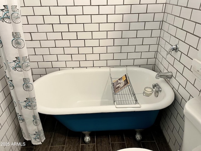 bathroom featuring tile walls and toilet