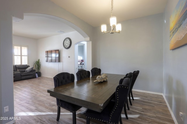 dining area with hardwood / wood-style floors and a chandelier