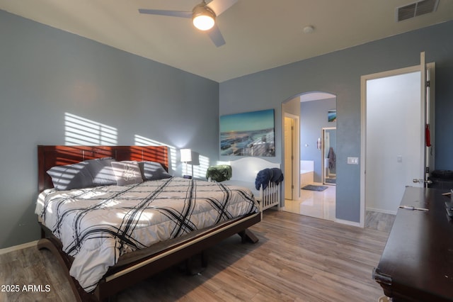 bedroom with ceiling fan, connected bathroom, and hardwood / wood-style floors