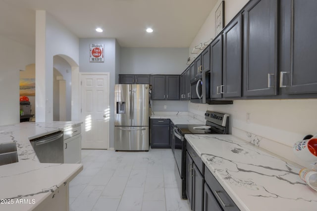 kitchen featuring stainless steel appliances and light stone countertops