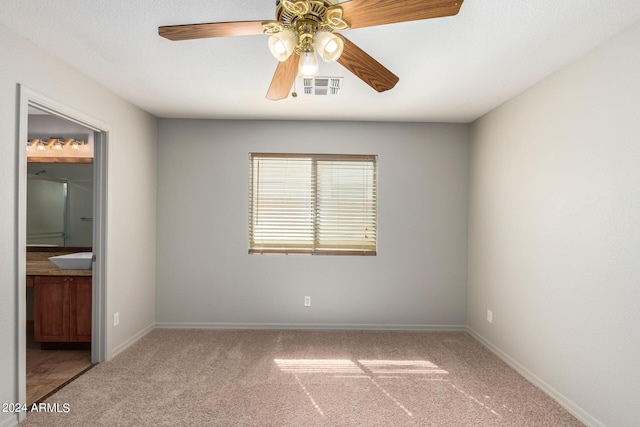 carpeted spare room with ceiling fan