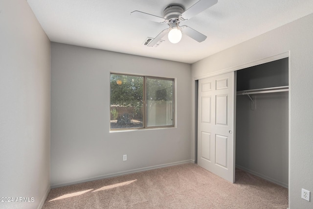 unfurnished bedroom with light carpet, ceiling fan, and a closet