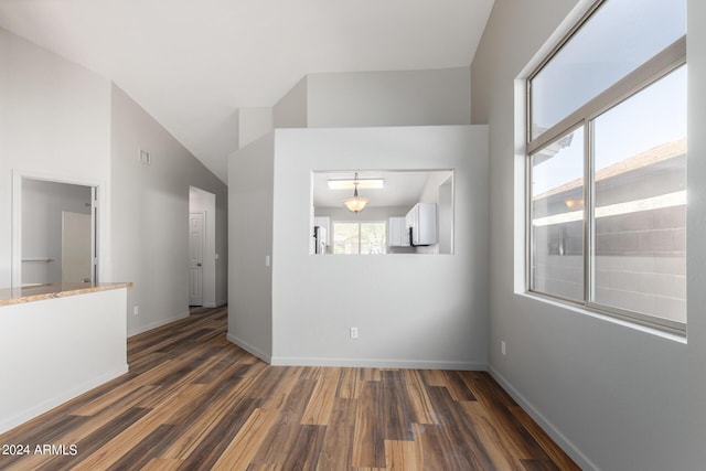 unfurnished room with vaulted ceiling and dark hardwood / wood-style floors