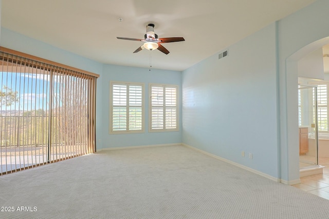 carpeted empty room featuring ceiling fan and a healthy amount of sunlight