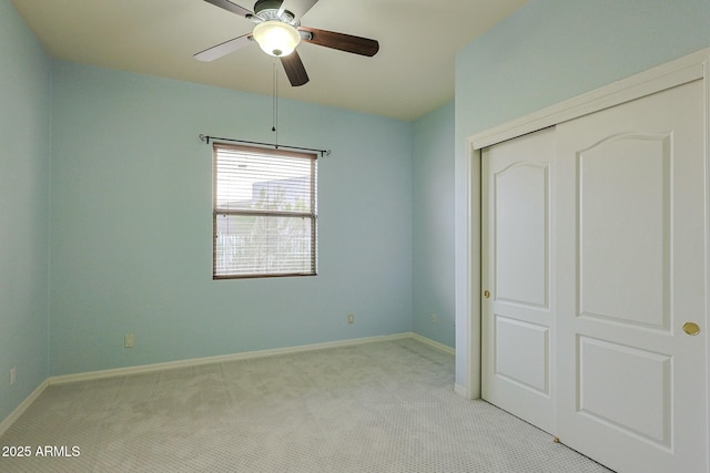 unfurnished bedroom with light colored carpet, a closet, and ceiling fan