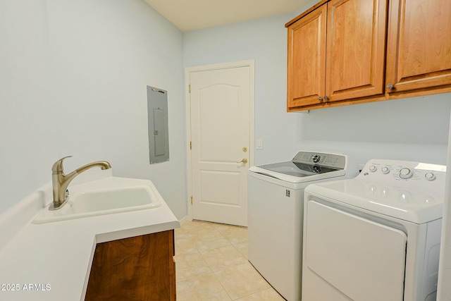 washroom featuring sink, light tile patterned floors, washing machine and dryer, cabinets, and electric panel