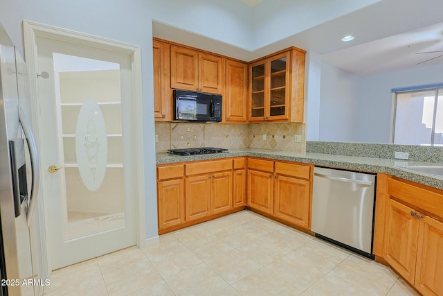 kitchen with stainless steel appliances, sink, light tile patterned floors, and backsplash