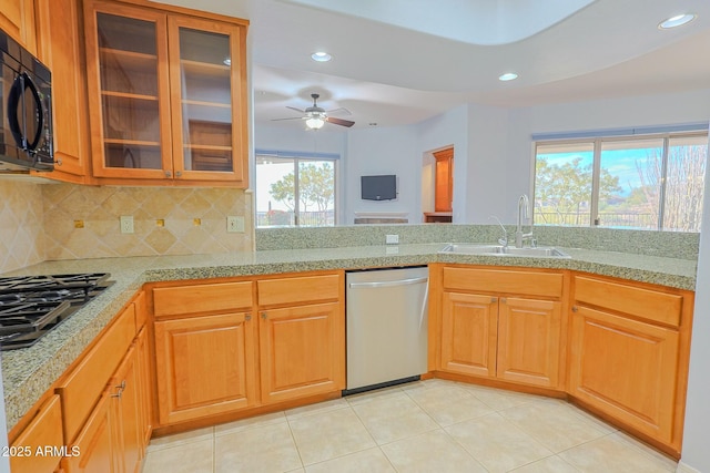 kitchen with tasteful backsplash, sink, light tile patterned floors, ceiling fan, and stainless steel appliances