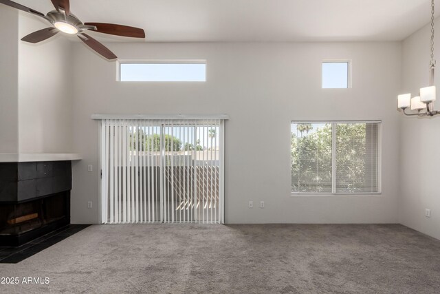 11260 N 92nd St Unit 2102, Scottsdale, AZ 85260 - unfurnished living room with a high ceiling, carpet floors, a ceiling fan, and a tile fireplace