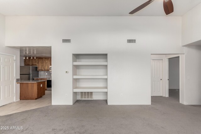 11260 N 92nd St Unit 2102, Scottsdale, AZ 85260 - unfurnished living room with light colored carpet, a ceiling fan, and a towering ceiling