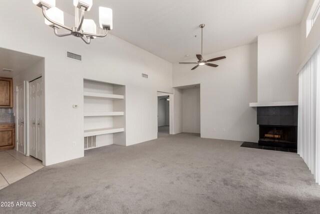 11260 N 92nd St Unit 2102, Scottsdale, AZ 85260 - unfurnished living room featuring carpet floors, a tiled fireplace, high vaulted ceiling, a ceiling fan, and built in shelves