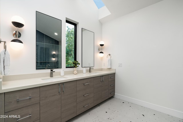 bathroom with lofted ceiling with skylight and vanity