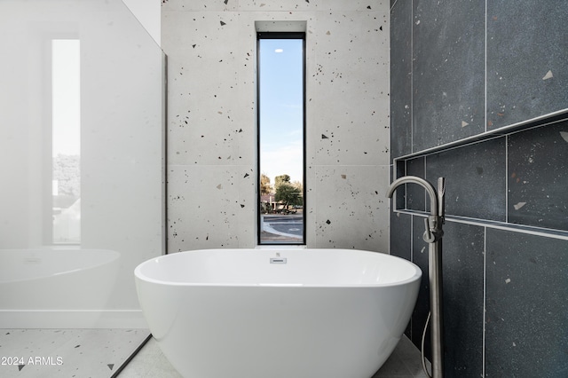 bathroom with tile patterned floors and a tub