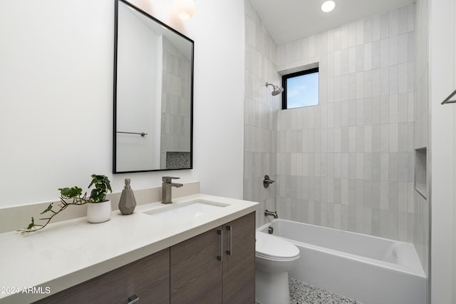 full bathroom with vanity, tiled shower / bath combo, and toilet