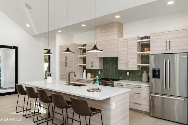 kitchen featuring decorative backsplash, light brown cabinetry, a center island with sink, decorative light fixtures, and stainless steel fridge with ice dispenser